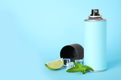 Photo of Spray deodorant, lime, mint and ice on light blue background, space for text