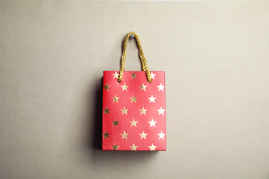 Red shopping paper bag with star pattern on grey background