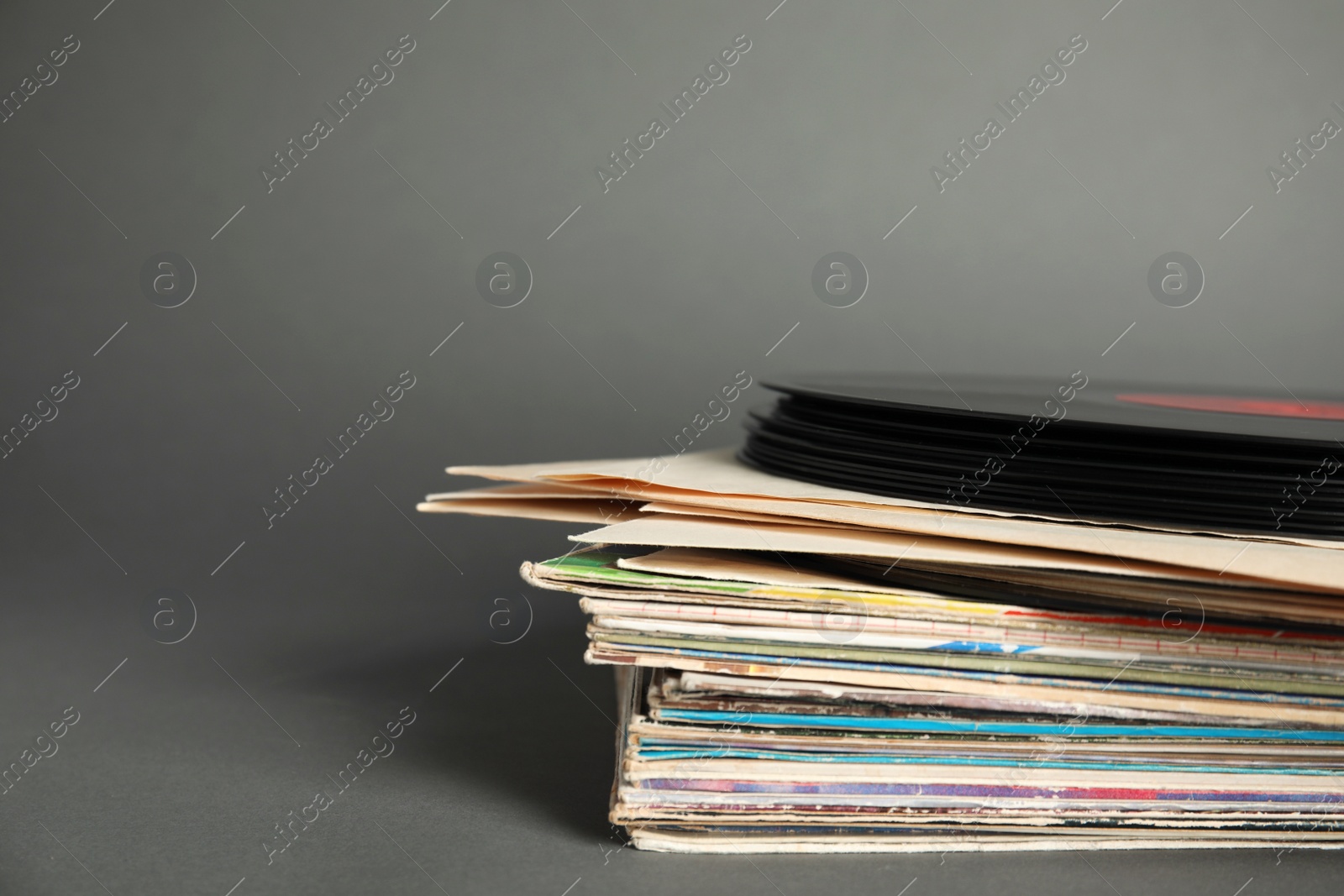 Photo of Stack of vintage vinyl records on grey background, closeup. Space for text