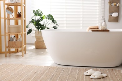 Photo of Set of different bath accessories and soap on tub in bathroom