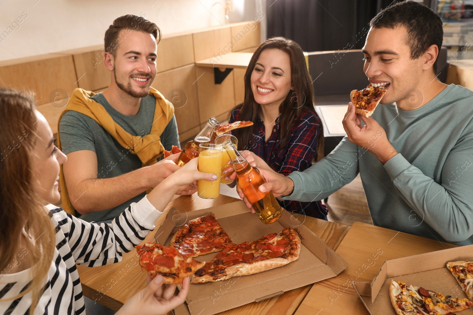 Photo of Group of friends having fun party with delicious pizza in cafe