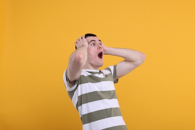 Portrait of surprised man on orange background