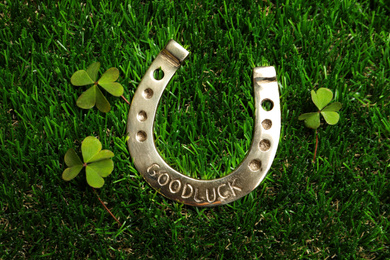 Photo of Flat lay composition with horseshoe on grass. St. Patrick's Day celebration
