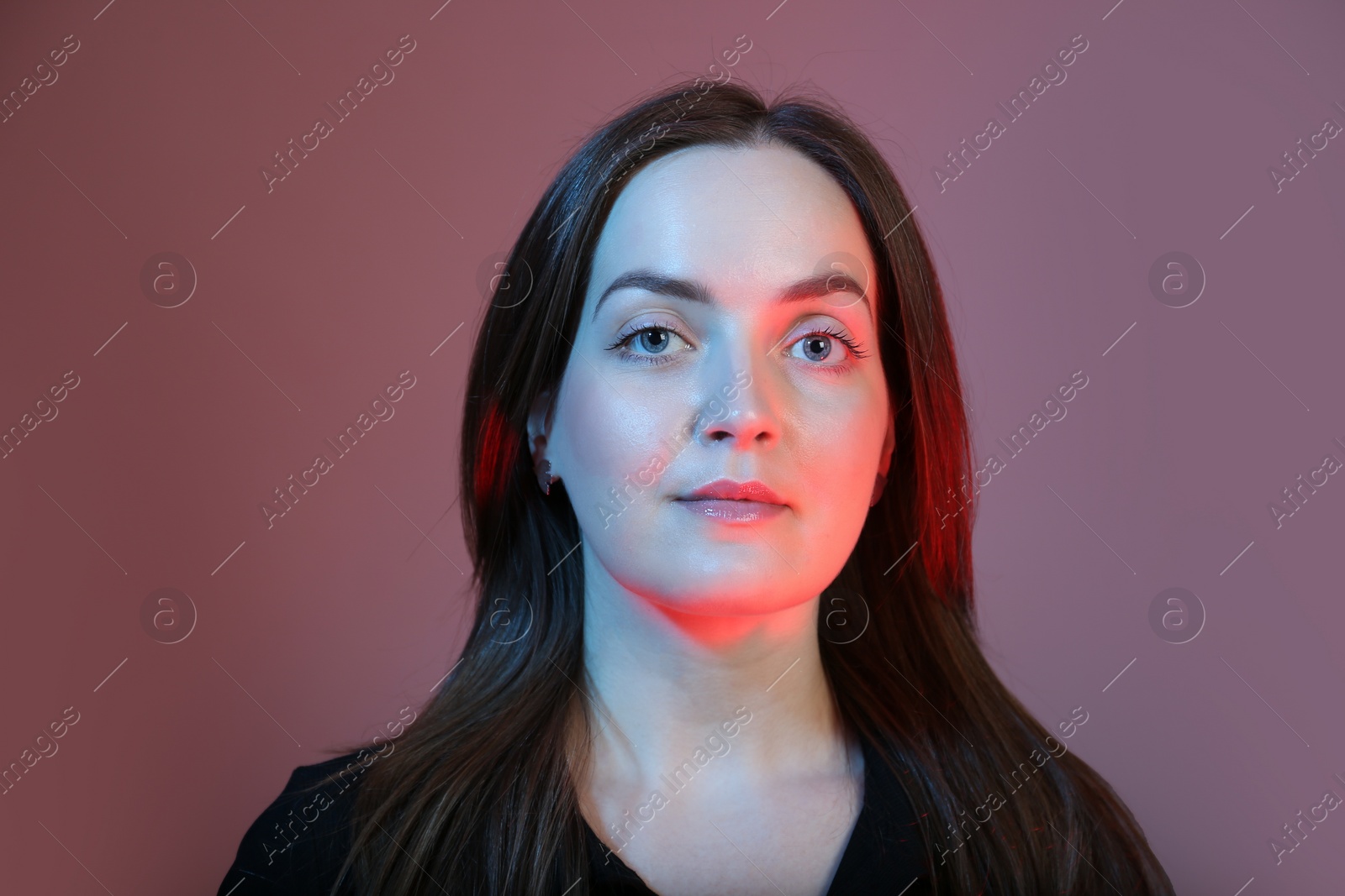 Photo of Portrait of beautiful young woman on color background with neon lights