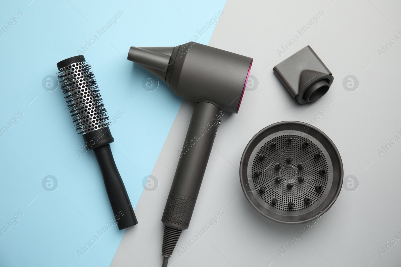 Photo of Hair dryer with nozzles and round brush on color background, flat lay