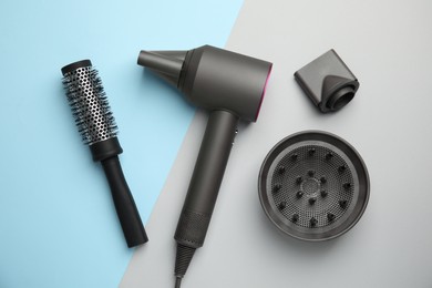 Photo of Hair dryer with nozzles and round brush on color background, flat lay