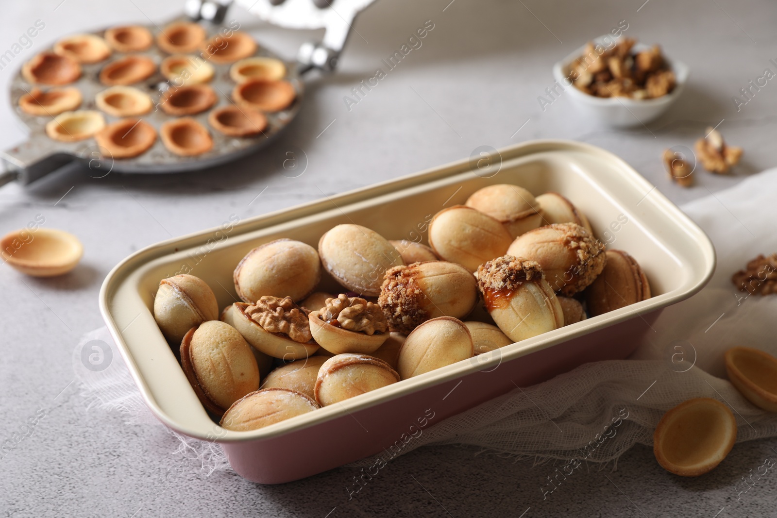 Photo of Freshly baked delicious walnut shaped cookies on light grey table