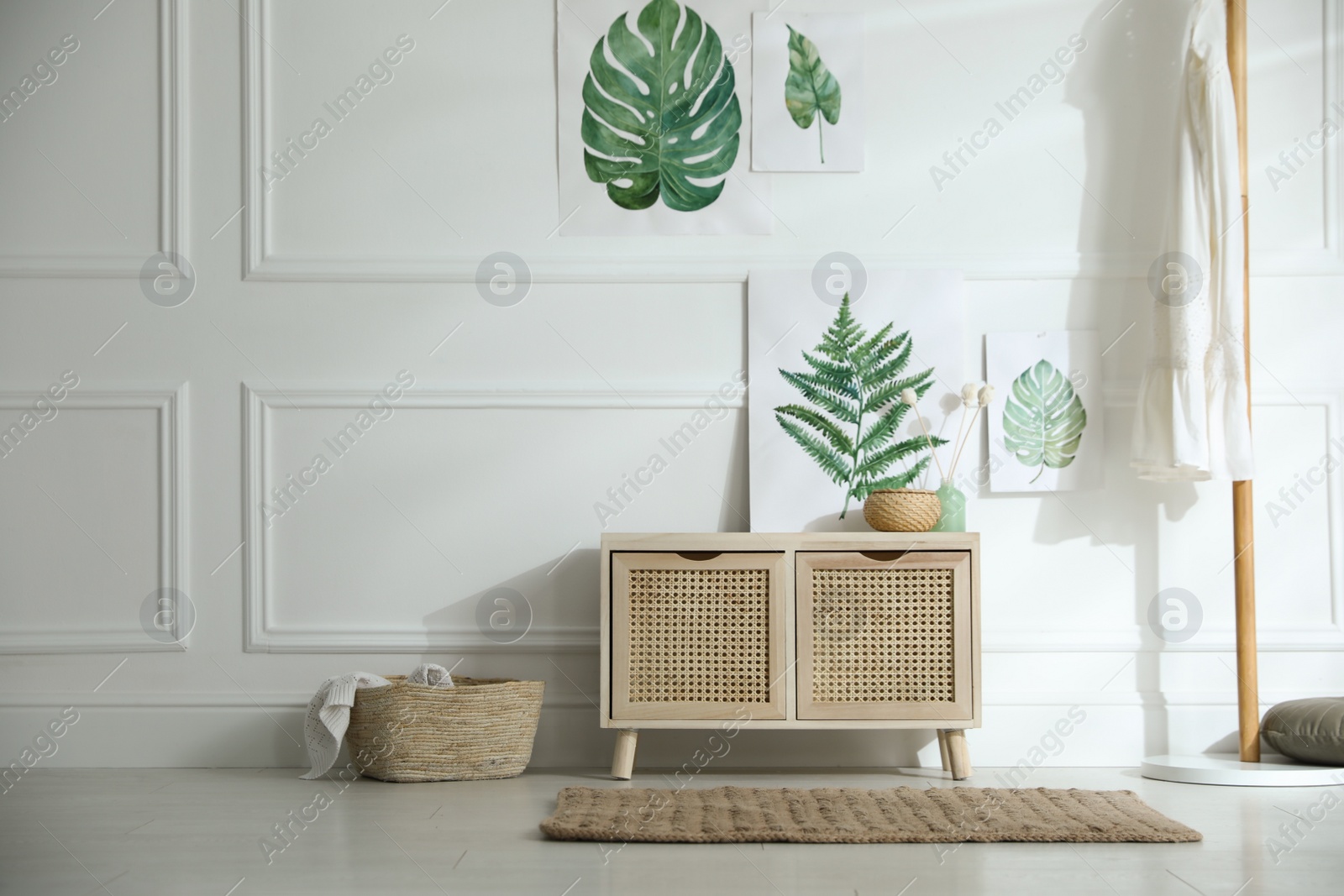 Photo of Wooden commode near white wall in room. Interior design