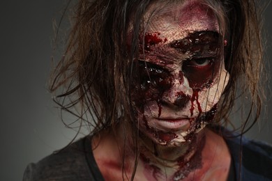 Photo of Scary zombie on dark background, closeup. Halloween monster