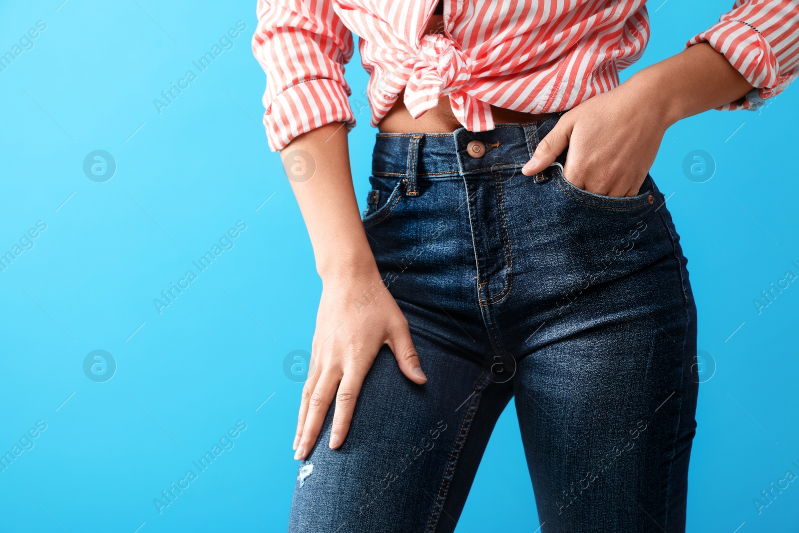 Photo of Woman wearing jeans on blue background, closeup