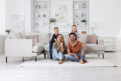 Photo of Portrait of happy family with children on soft rug at home