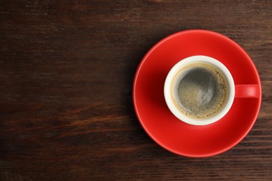 Photo of Cup of hot aromatic espresso on wooden table, top view. Space for text