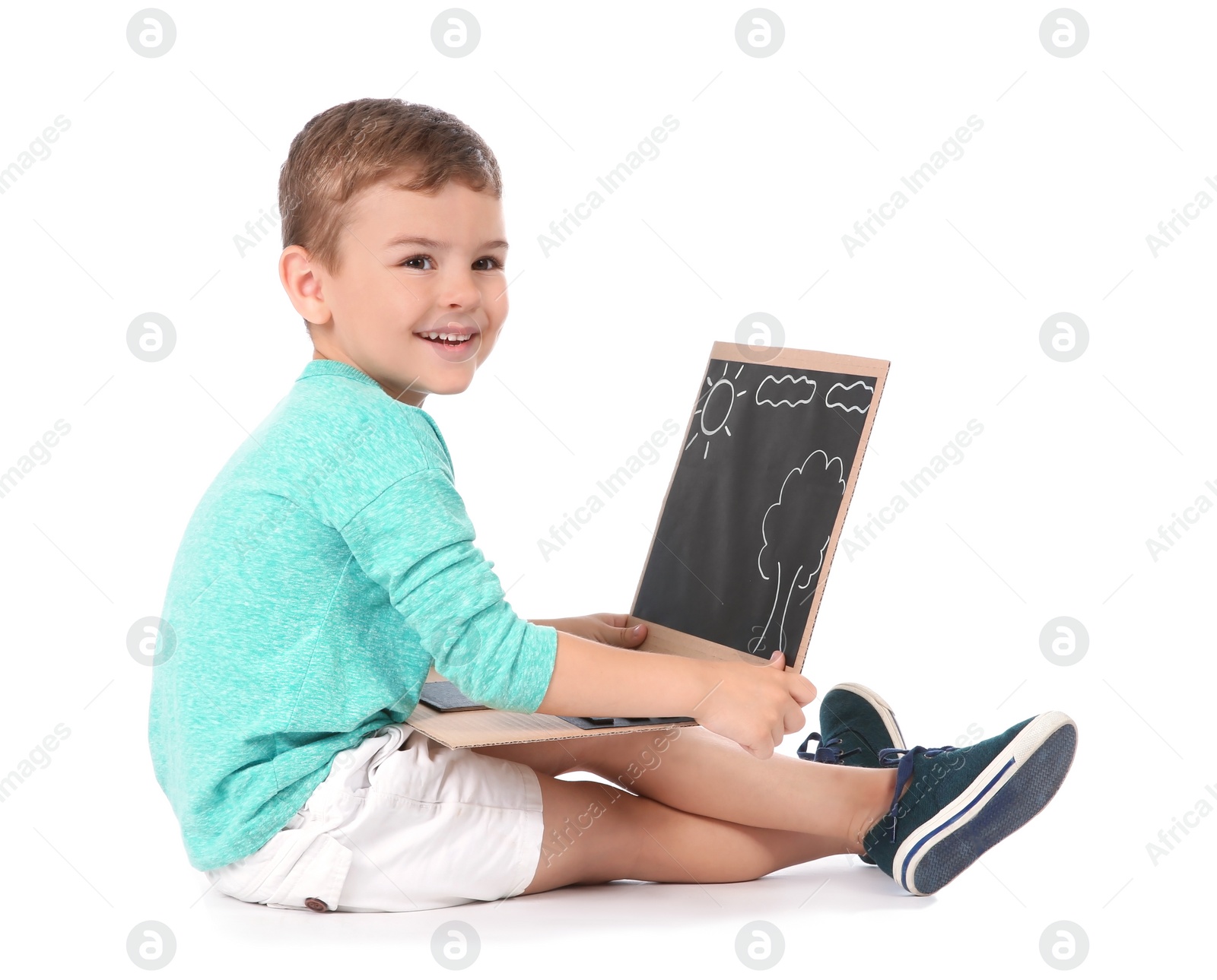 Photo of Little child playing with carton laptop on white background. Indoor entertainment