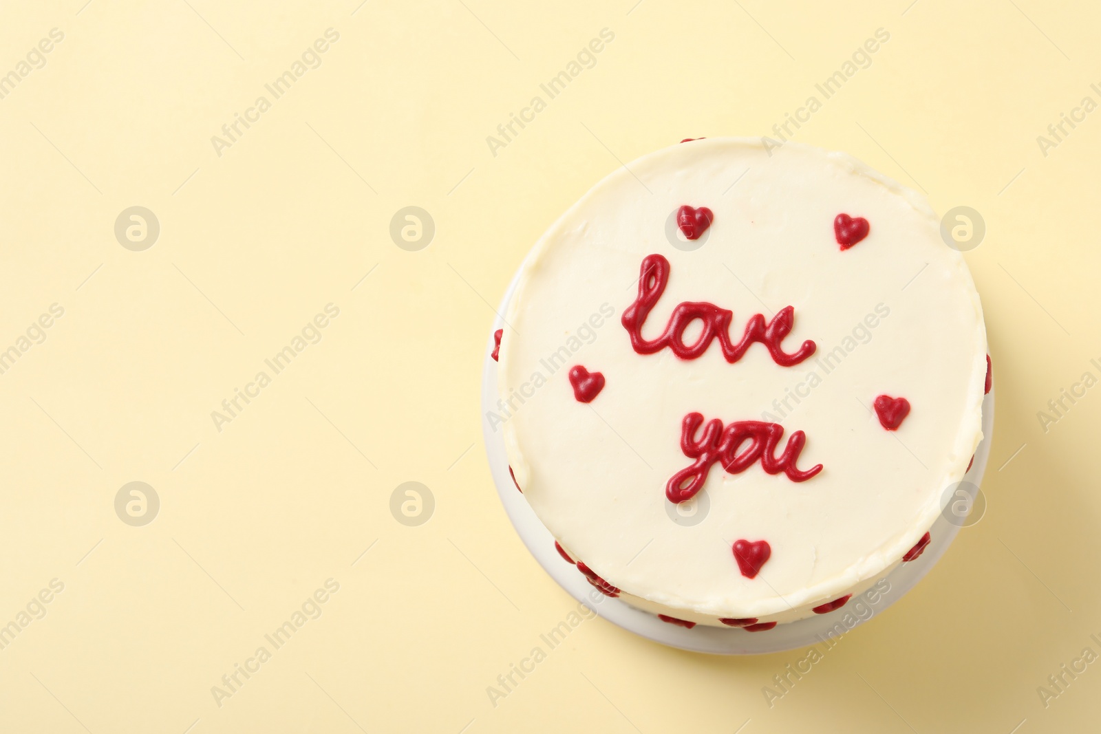 Photo of Bento cake with text Love You and space for text on beige table, top view. St. Valentine's day surprise