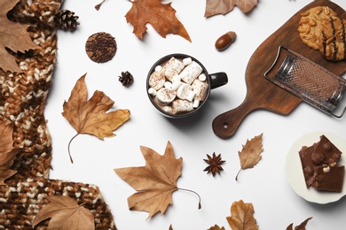 Flat lay composition with hot cozy drink and autumn leaves on white background