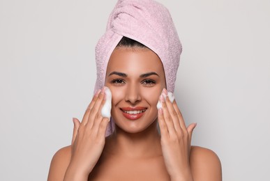 Photo of Beautiful woman applying facial cleansing foam on white background