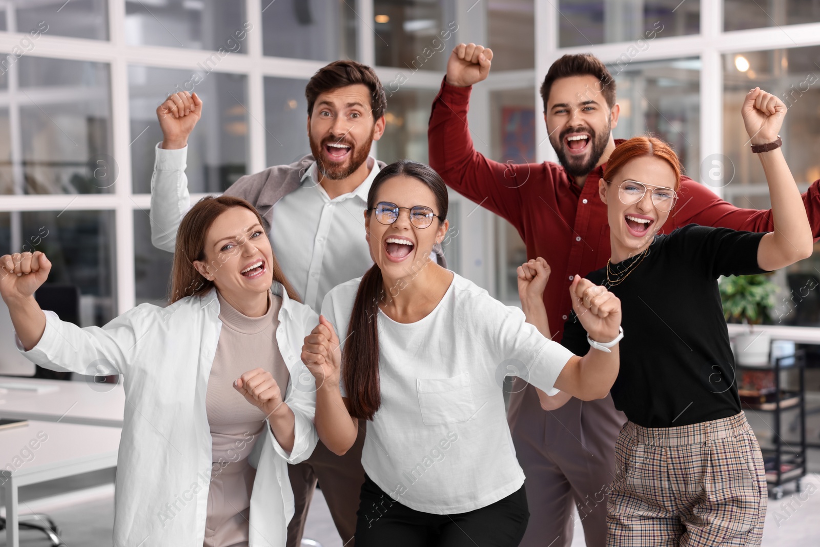 Photo of Team of employees celebrating success in office