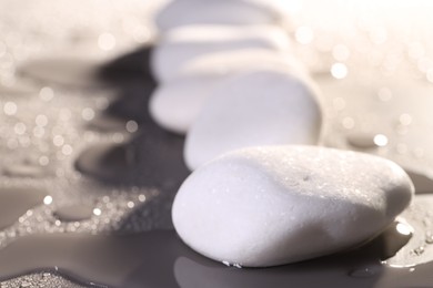 Photo of White spa stones with water drops on grey background, closeup