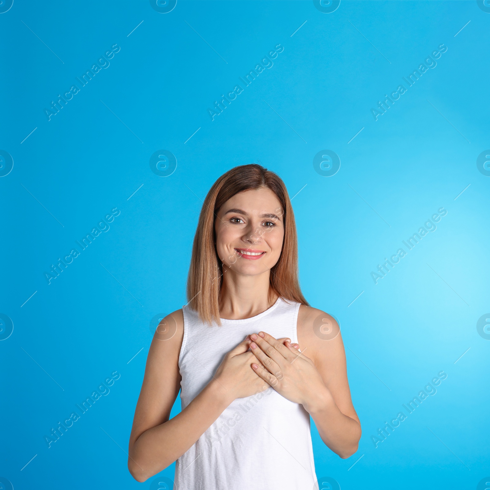 Photo of Portrait of woman holding hands near heart on color background