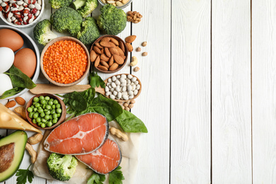 Photo of Products rich in protein on white wooden table, flat lay. Space for text