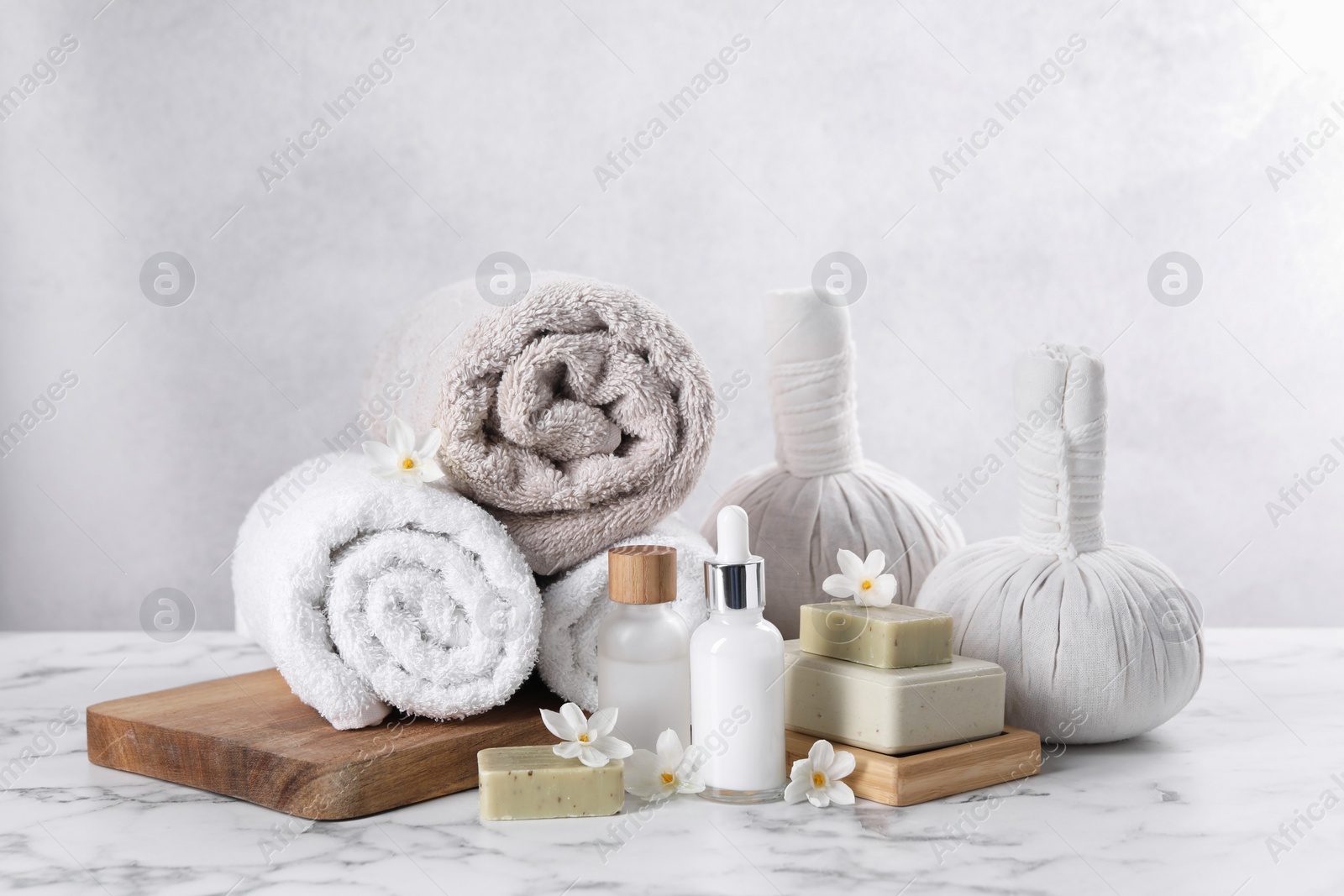 Photo of Composition with spa supplies and flowers on white marble table