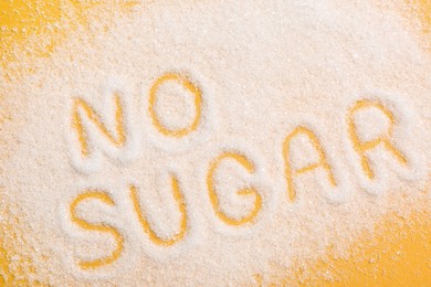 Photo of Phrase No Sugar made of granules on yellow background, flat lay