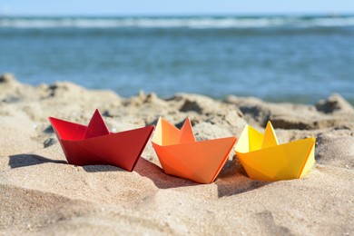 Photo of Three paper boats near sea on sunny day