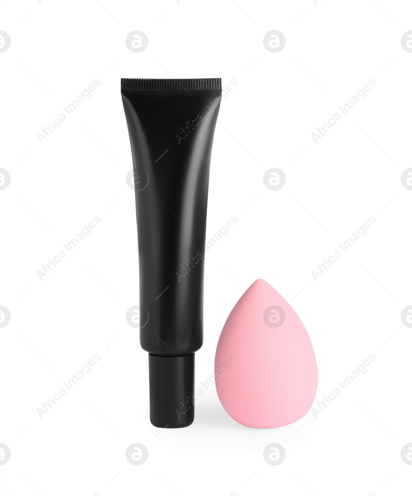 Photo of Tube of skin foundation and sponge on white background. Makeup product