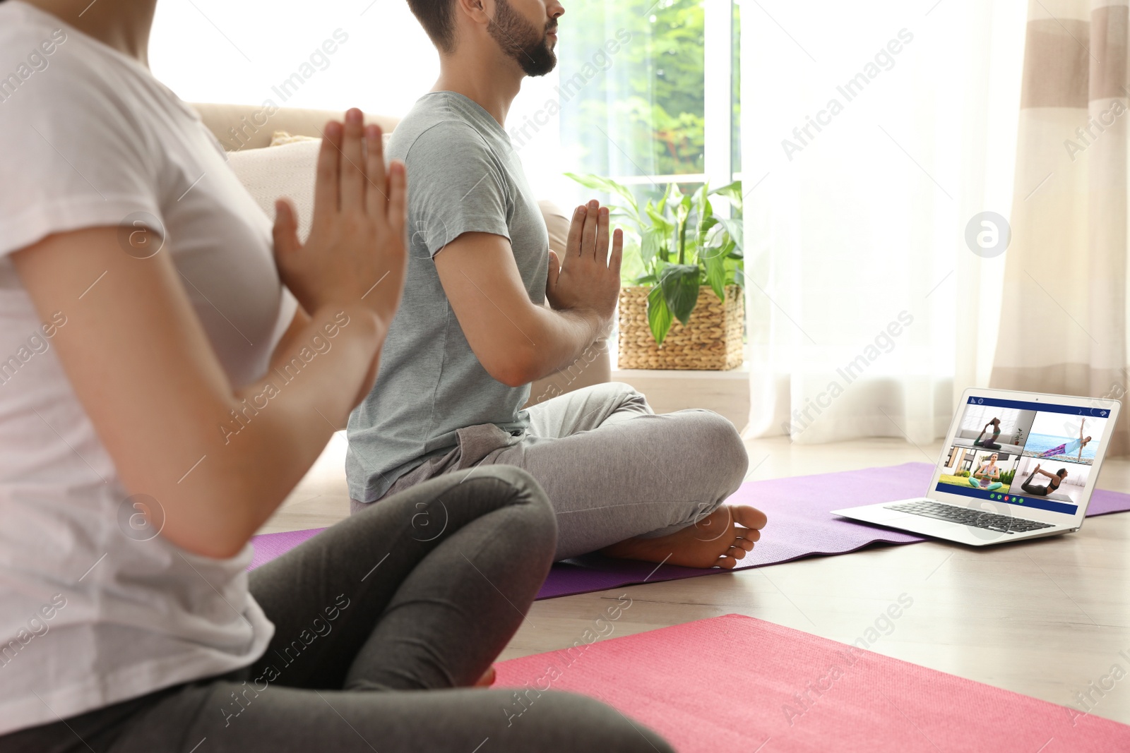 Image of Distance yoga course during coronavirus pandemic. Couple having online video class via laptop at home