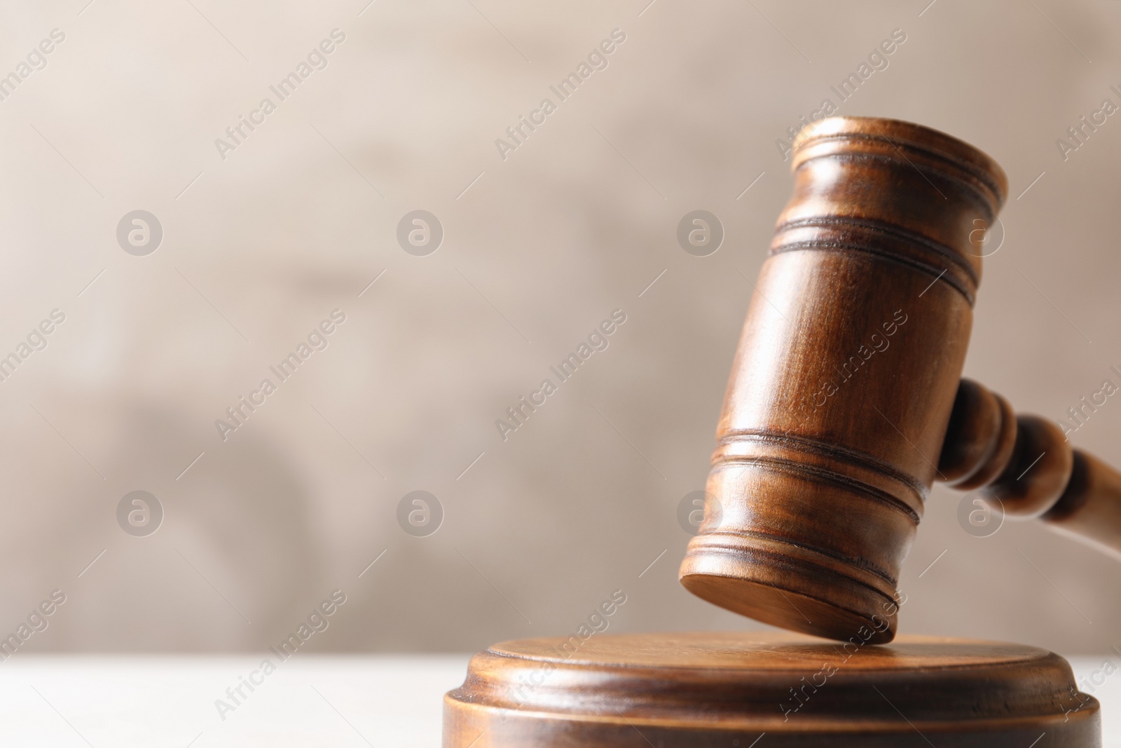 Photo of Wooden gavel on table against color background, closeup. Law concept