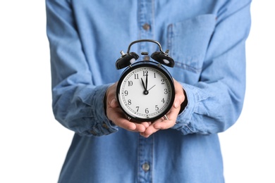 Young woman holding alarm clock on white background. Time concept