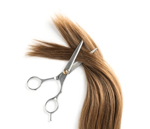 Photo of Light brown hair and scissors on white background, top view. Hairdresser service