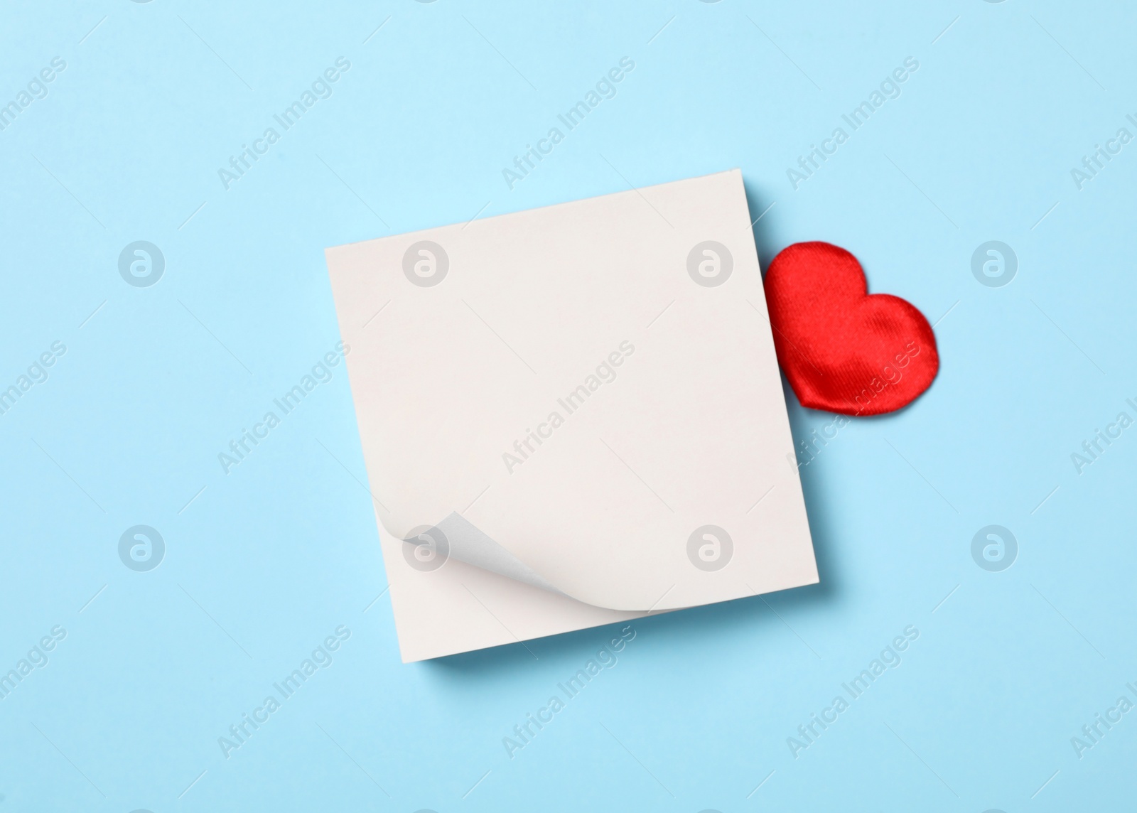 Photo of Blank notes and decorative heart on light blue background, flat lay with space for text. Valentine's Day celebration