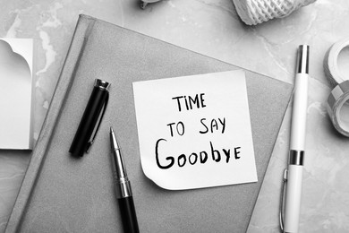 Image of Note with text Tome to say Goodbye and stationery on table, flat lay. Black and white tone