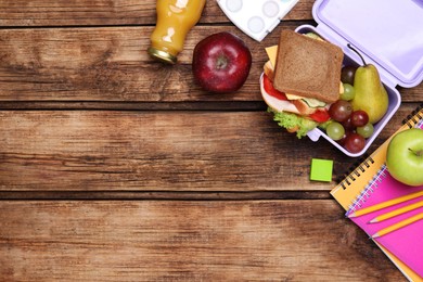 Photo of Flat lay composition with lunch box, tasty healthy food and school stationery on wooden table. Space for text