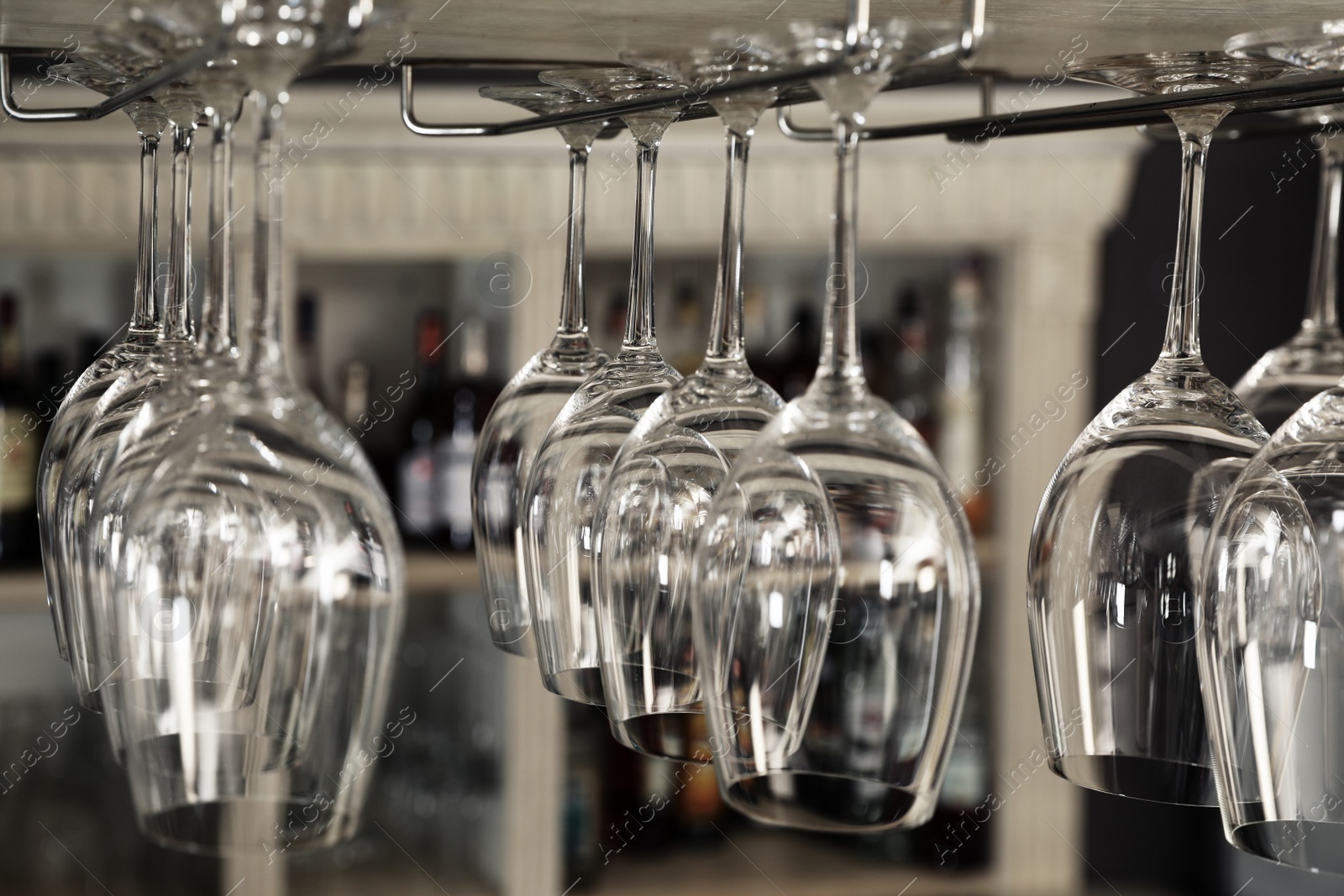 Photo of Set of empty clean glasses on bar racks