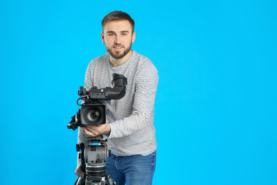 Photo of Operator with professional video camera on blue background, space for text