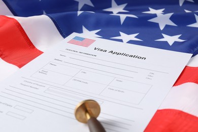 Immigration to USA. Visa application form and stamp on flag, closeup