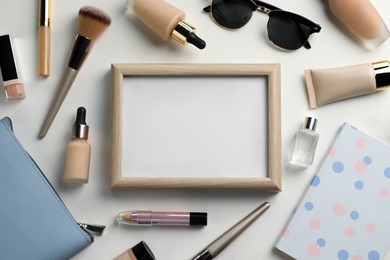 Photo of Blank board with makeup products and tools on white background, flat lay. Space for text