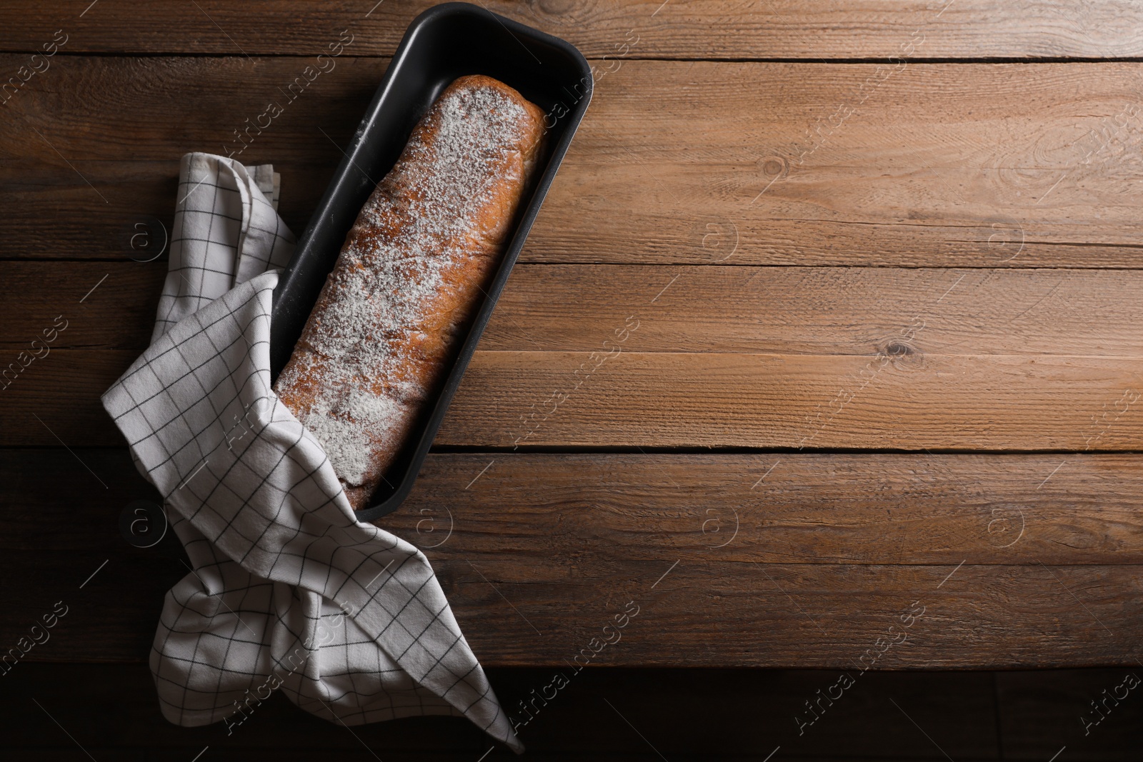 Photo of Fresh crispy ciabatta on wooden table, top view. Space for text