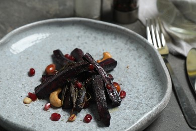 Photo of Tasty baked black carrot on table, closeup