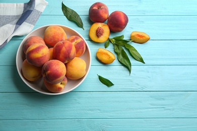 Photo of Fresh sweet peaches on turquoise wooden table, flat lay. Space for text