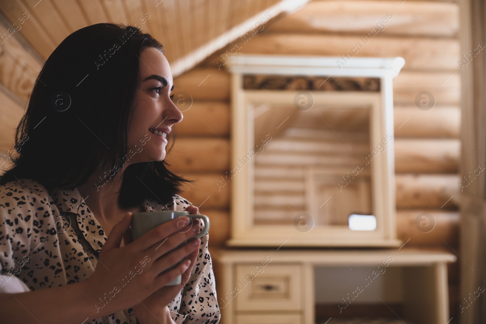 Photo of Young woman in pajamas with drink at home. Lazy morning