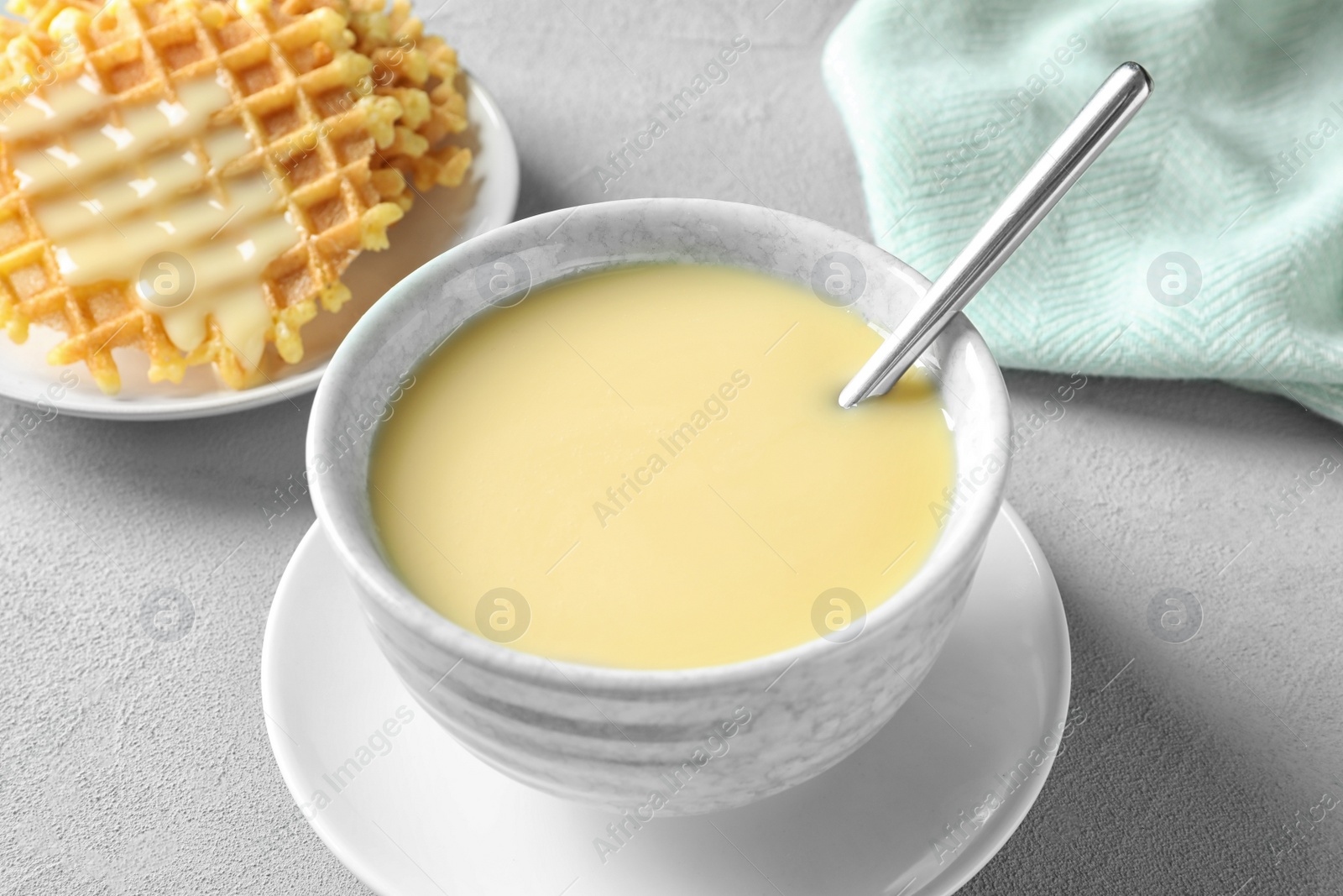 Photo of Bowl with condensed milk served on table. Dairy products