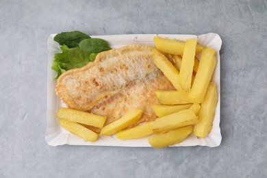 Photo of Delicious fish and chips with spinach and lettuce on gray table, top view