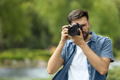 Photo of Photographer taking photo with professional camera in park
