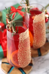 Photo of Christmas Sangria cocktail in glasses on white marble table, closeup