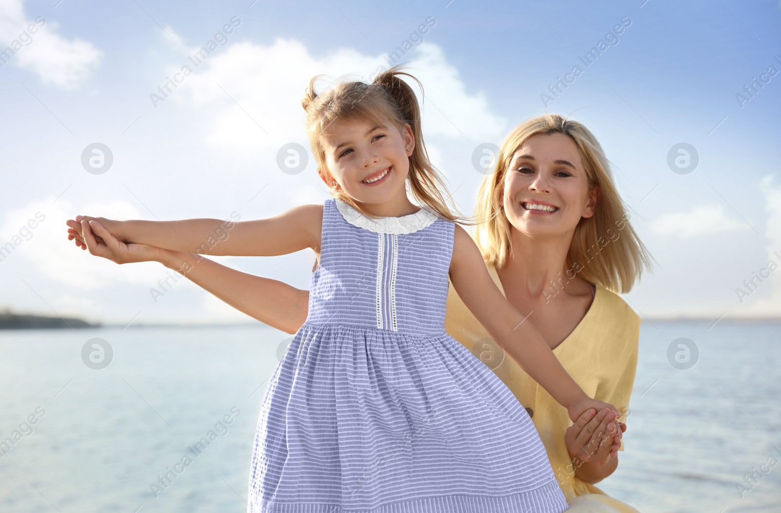 Photo of Happy mother and her child on beach. Spending time in nature