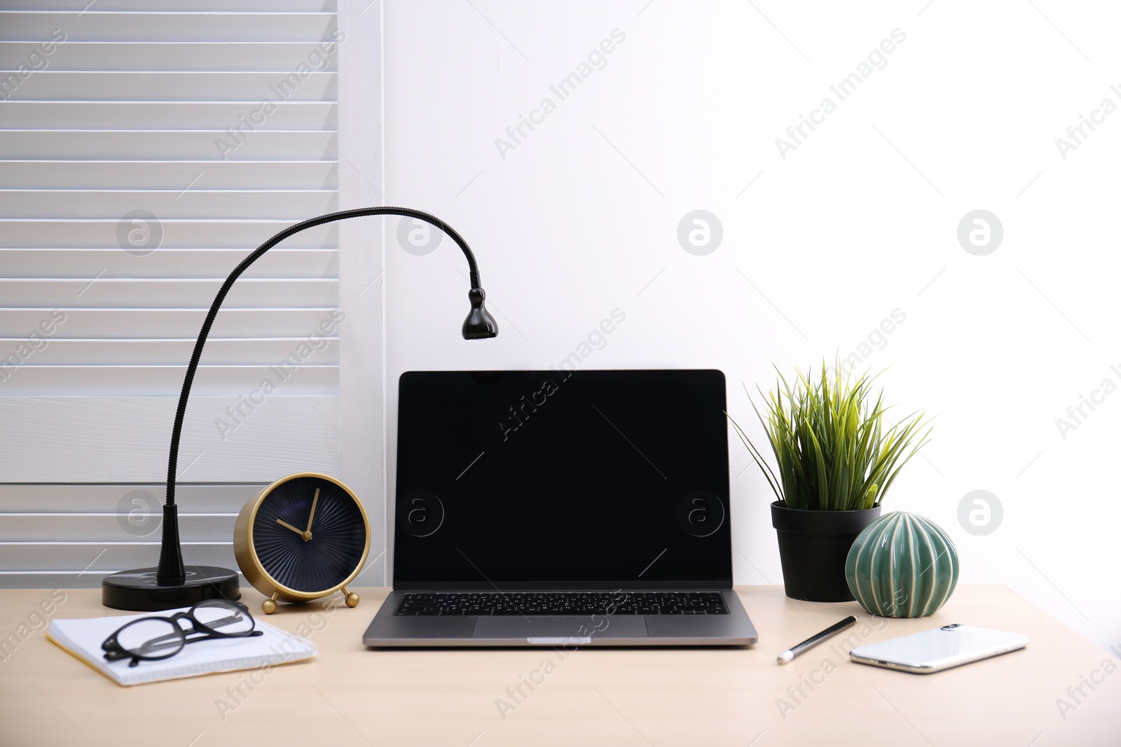 Photo of Modern workplace with laptop on table. Blank screen for mockup