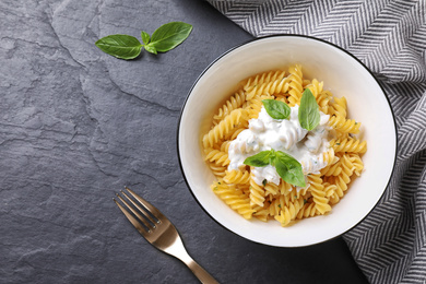 Delicious pasta with sauce served on black table, flat lay